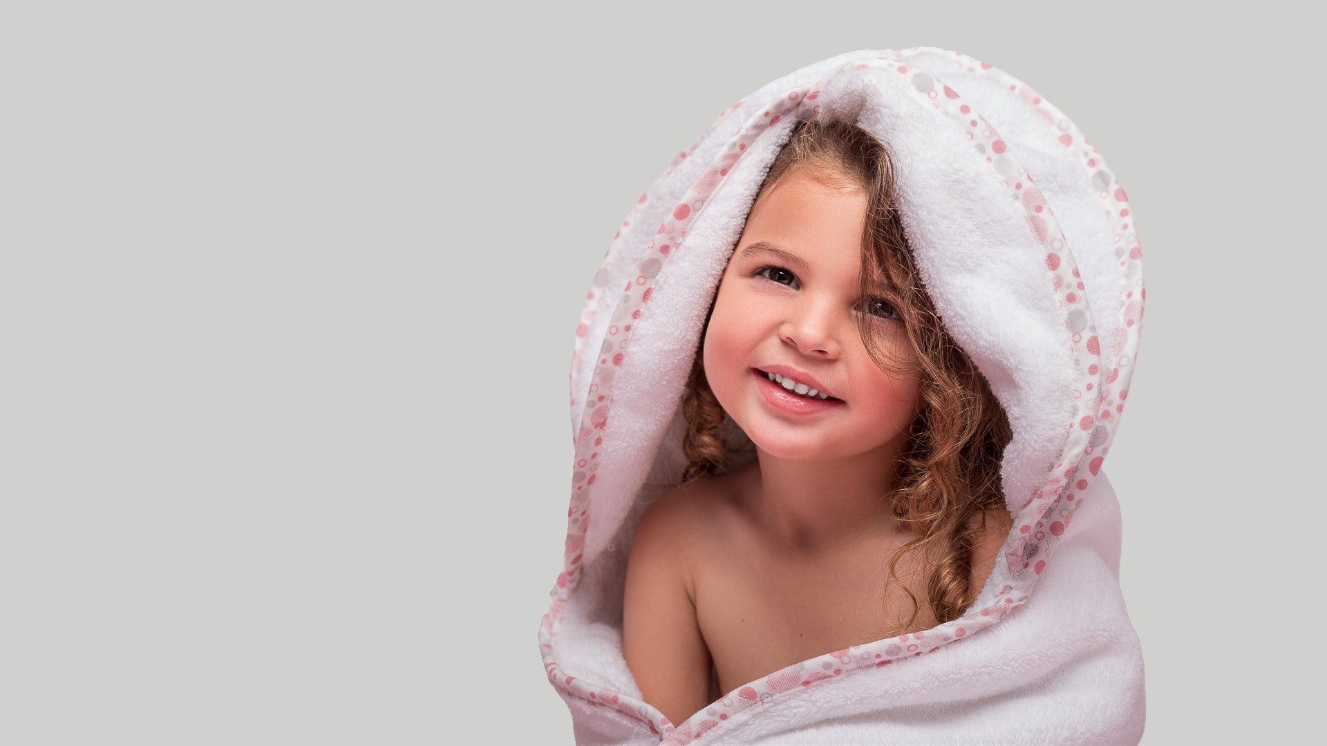Smiling toddler wrapped in a plush EleryB towel, radiating comfort and joy after bathtime

