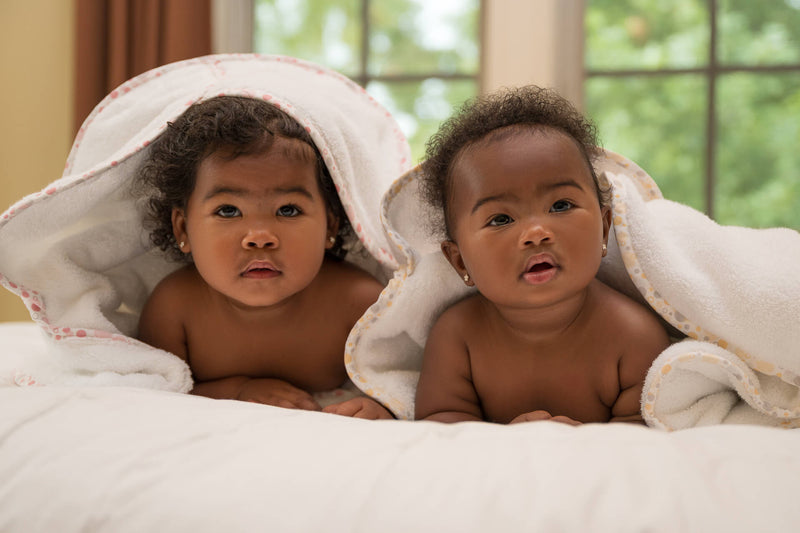 Two smiling young girls wrapped in plush EleryB towels, cozy and joyful after bathtime
