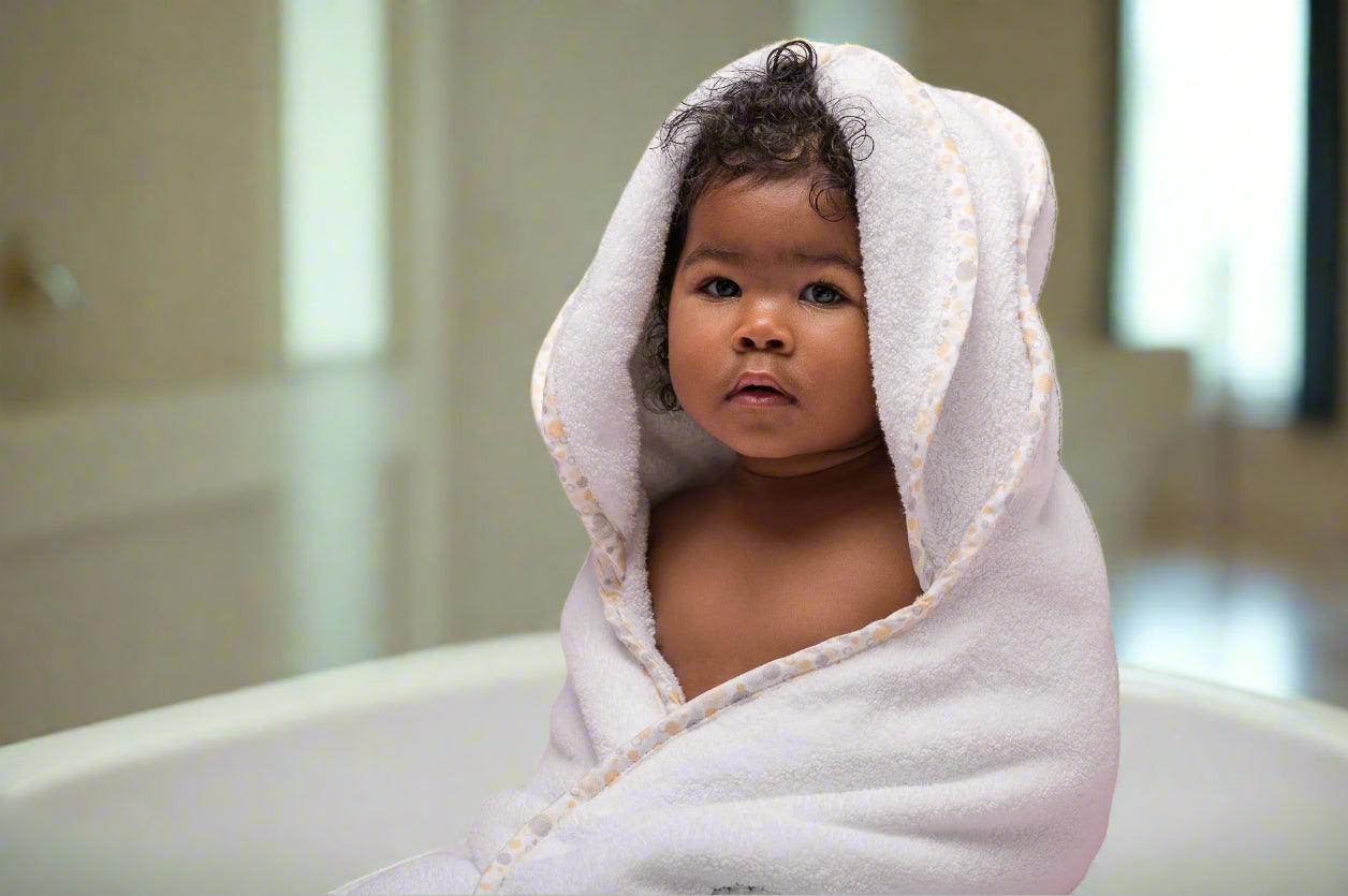 Toddler in hypoallergenic EleryB hooded towel with yellow geometric trim and folded head flaps
